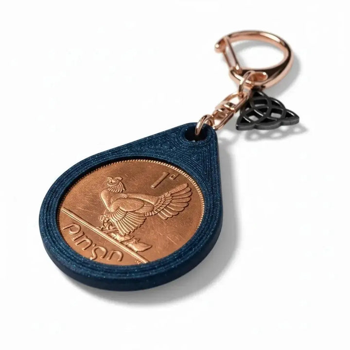 Irish penny with a hen and chicks set in a blue teardrop keyring with a Celtic knot charm