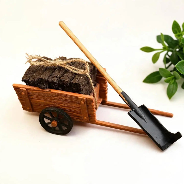 Miniature turf cart loaded with turf sods tied with twine, a sleán spade resting on it